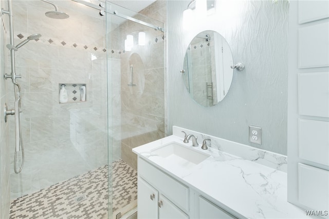 bathroom featuring vanity and a shower with door