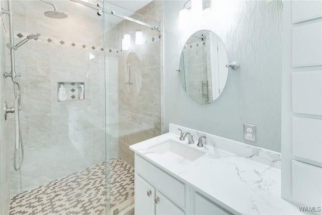 bathroom with vanity and a shower with door