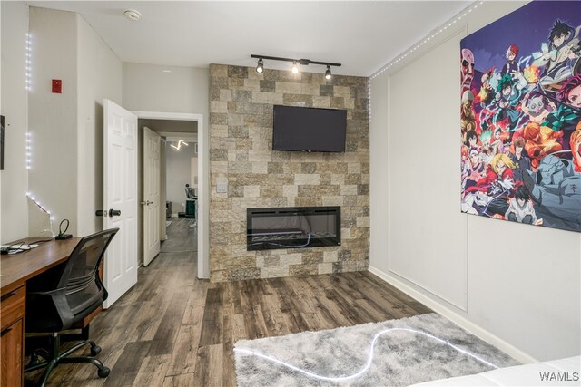 office area featuring a fireplace, rail lighting, and dark hardwood / wood-style floors