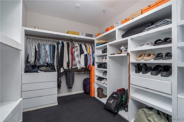 walk in closet featuring dark colored carpet