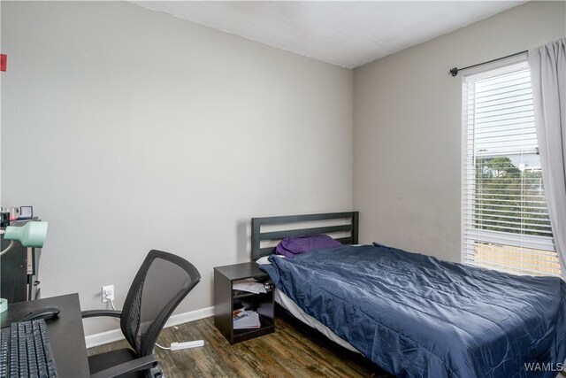 bedroom with dark hardwood / wood-style flooring