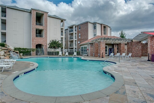 view of swimming pool with pool water feature and a patio