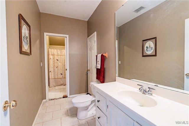 bathroom with toilet, vanity, and tile patterned floors