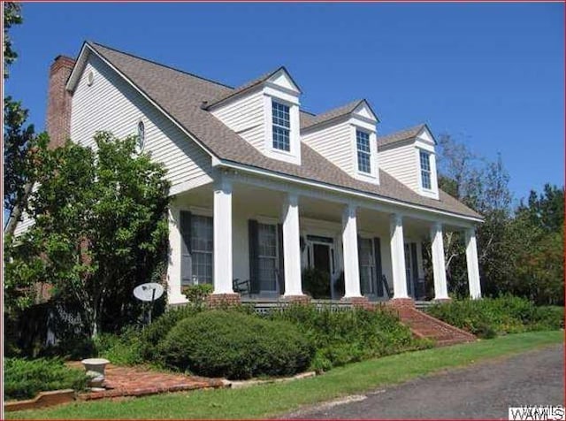 cape cod-style house featuring covered porch