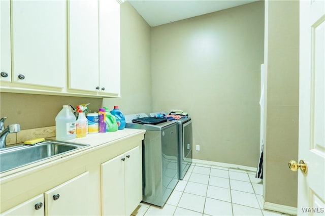 laundry area with light tile patterned floors, sink, washing machine and clothes dryer, and cabinets