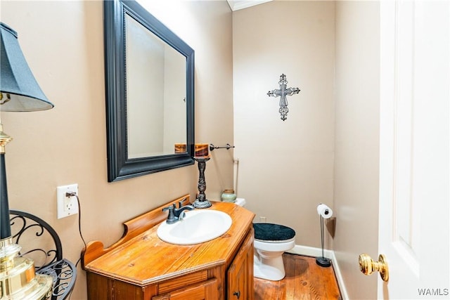 bathroom with toilet, wood-type flooring, and vanity