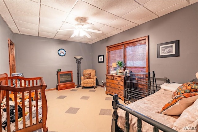 bedroom with ceiling fan and a drop ceiling