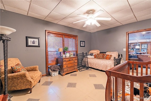 bedroom with ceiling fan and a paneled ceiling