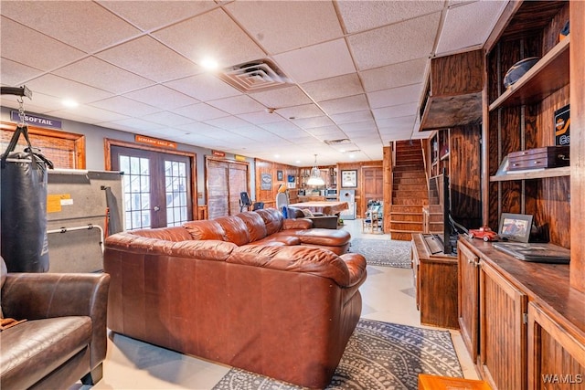 living room featuring french doors and wooden walls