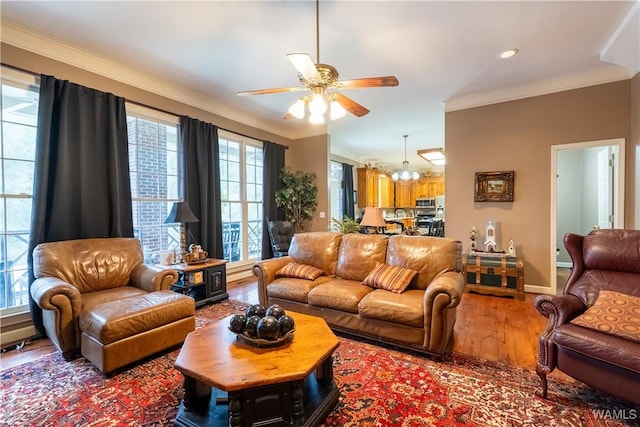 living room featuring a healthy amount of sunlight, wood-type flooring, and ornamental molding