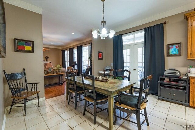 tiled dining room featuring ornamental molding, french doors, and a notable chandelier