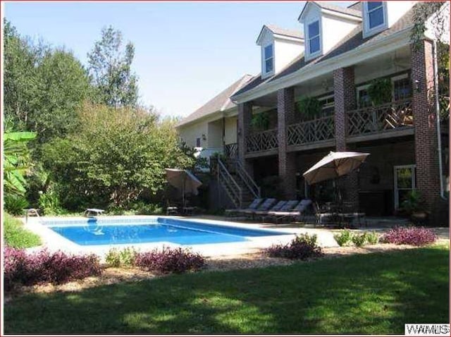 view of pool featuring a diving board and a yard