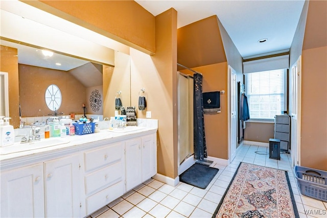 bathroom with vaulted ceiling, tile patterned flooring, walk in shower, and vanity