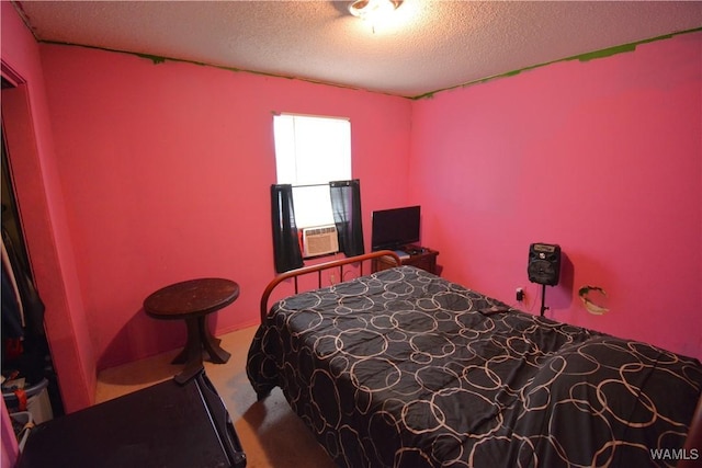 bedroom featuring carpet floors, cooling unit, and a textured ceiling