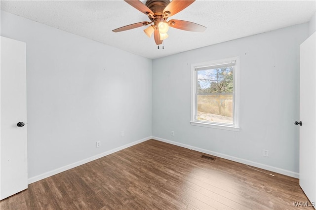 unfurnished room featuring a textured ceiling, a ceiling fan, baseboards, and wood finished floors