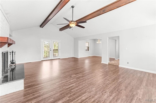 unfurnished living room featuring a brick fireplace, baseboards, ceiling fan, beamed ceiling, and wood finished floors