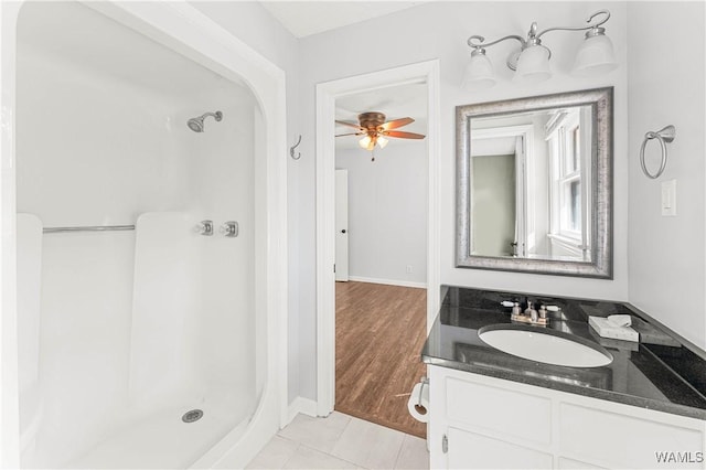 full bathroom with vanity, a stall shower, a ceiling fan, and tile patterned flooring