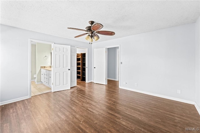 unfurnished bedroom with wood finished floors, baseboards, and a textured ceiling