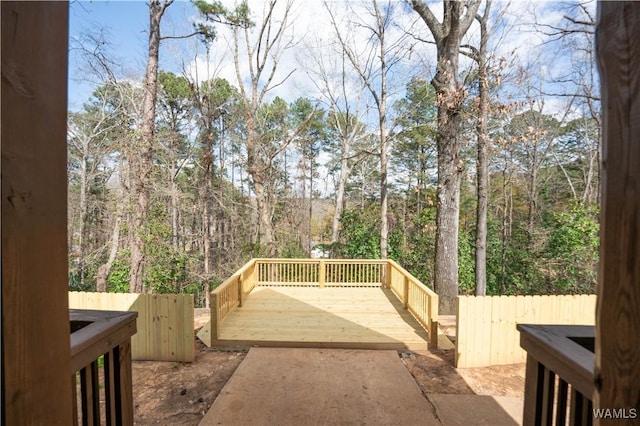 exterior space featuring a wooded view and fence