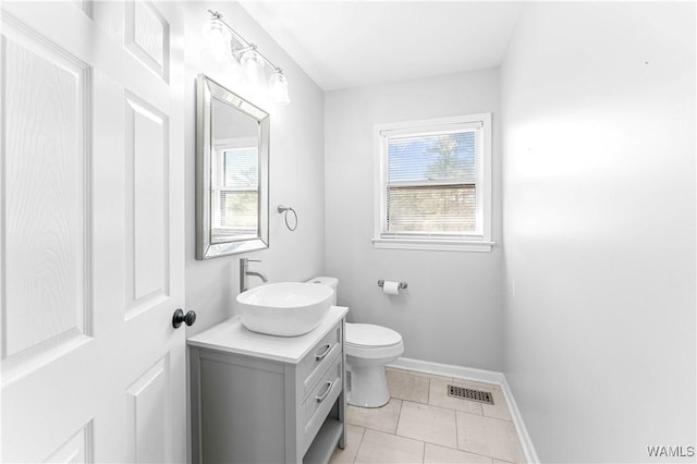 half bathroom featuring visible vents, plenty of natural light, toilet, and baseboards