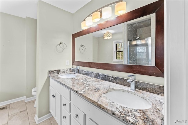 bathroom featuring a sink, toilet, tile patterned flooring, and a tile shower