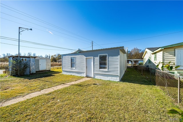 rear view of house featuring a yard and a shed