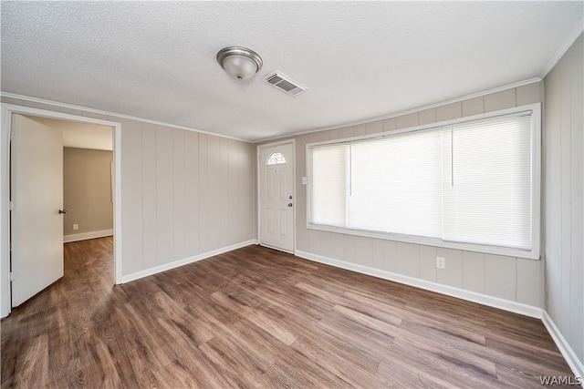 empty room with wood-type flooring and a textured ceiling