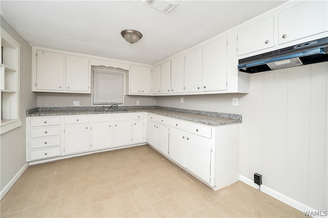 kitchen featuring white cabinets, a textured ceiling, and sink