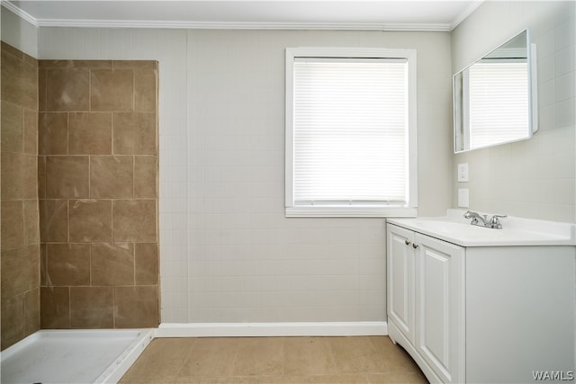 bathroom with a tile shower, vanity, tile patterned floors, and ornamental molding