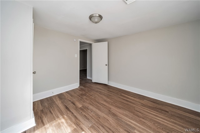 unfurnished room with dark hardwood / wood-style flooring