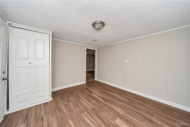 unfurnished bedroom featuring hardwood / wood-style flooring, a textured ceiling, and a closet