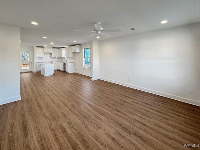 unfurnished living room with dark hardwood / wood-style floors, ceiling fan, and sink