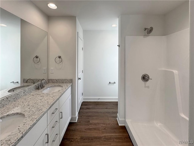 bathroom featuring vanity, wood-type flooring, and walk in shower