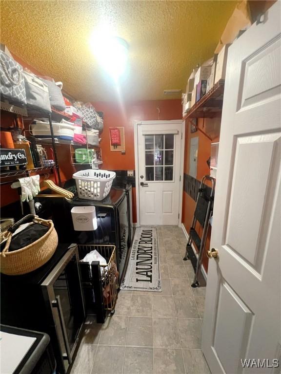 2712 Shady Bank Ln, Northport, AL 35473 - washroom featuring washing machine and dryer, light tile patterned floors, and a textured ceiling