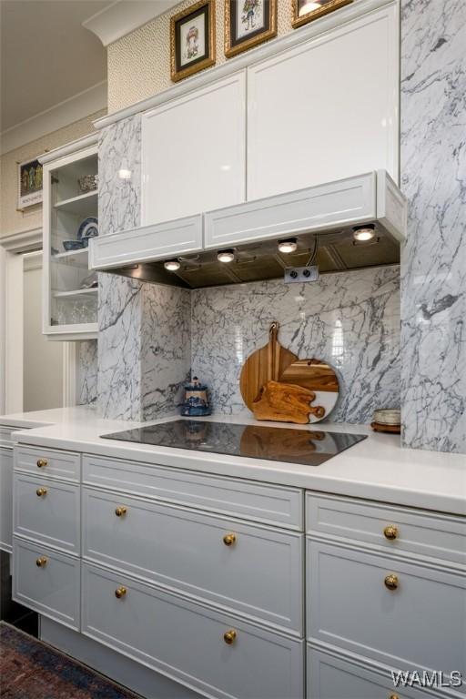 kitchen featuring appliances with stainless steel finishes, ornamental molding, extractor fan, dark tile patterned floors, and white cabinets