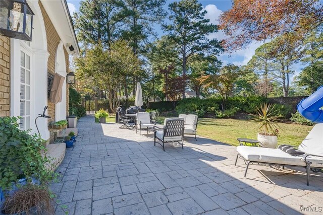 rear view of house featuring french doors, an outdoor living space, a patio area, and a lawn