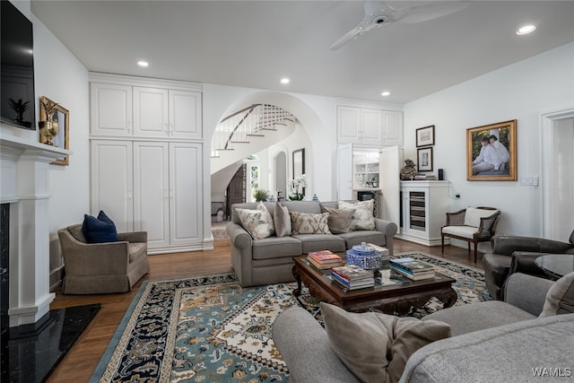 living room featuring ceiling fan, dark hardwood / wood-style flooring, and a high end fireplace