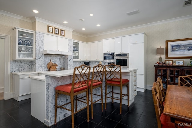 kitchen featuring white cabinets, a kitchen island, and ornamental molding