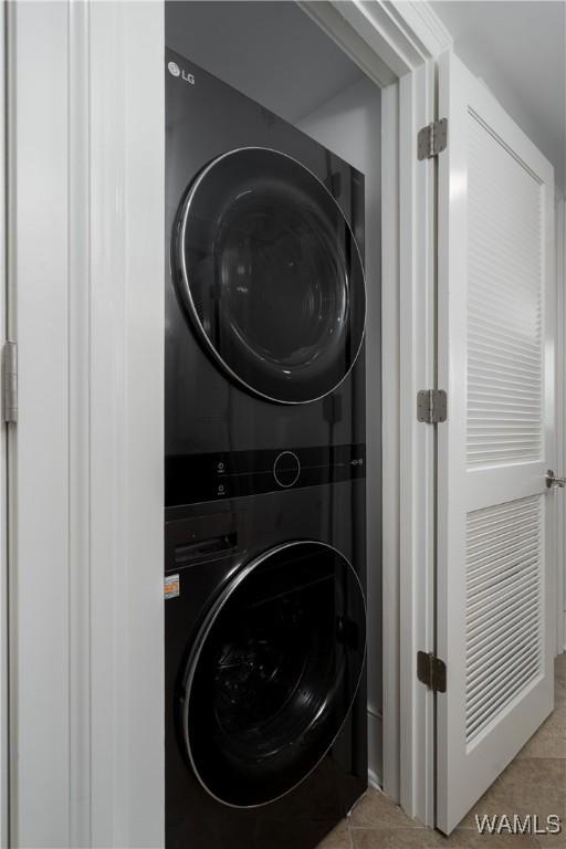 1018 Hackberry Ln Unit 301, Tuscaloosa, AL 35401 - washroom with estacked washer and dryer and tile patterned flooring