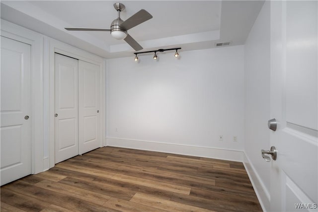 1018 Hackberry Ln Unit 301, Tuscaloosa, AL 35401 - unfurnished bedroom featuring wood finished floors, a ceiling fan, a closet, and a tray ceiling