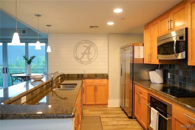1018 Hackberry Ln Unit 113, Tuscaloosa, AL 35401 - kitchen featuring appliances with stainless steel finishes, light wood-style flooring, tasteful backsplash, recessed lighting, and dark stone counters