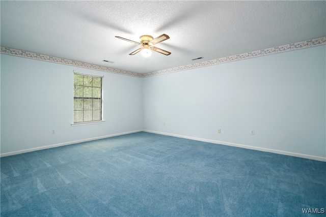 empty room with ceiling fan, dark carpet, and a textured ceiling