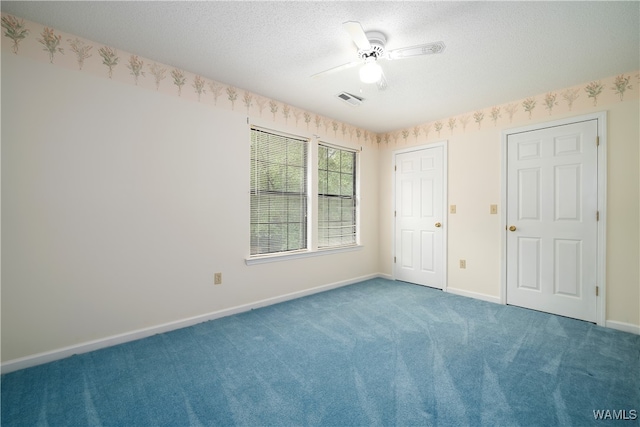 unfurnished bedroom featuring carpet, a textured ceiling, and ceiling fan