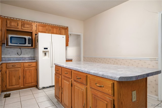 kitchen with white fridge with ice dispenser, a kitchen island, and light tile patterned floors