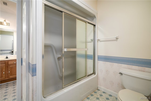 full bathroom featuring combined bath / shower with glass door, vanity, and toilet