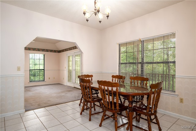 dining area with light colored carpet and a chandelier