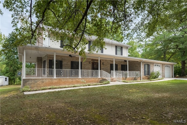 view of front of property featuring a porch, a garage, and a front yard