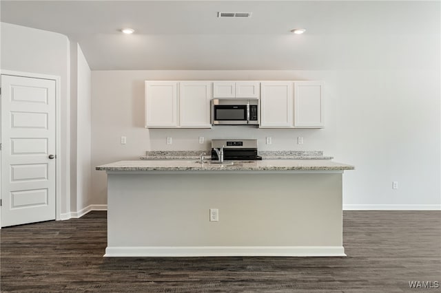 kitchen with light stone countertops, dark hardwood / wood-style flooring, white cabinets, and appliances with stainless steel finishes