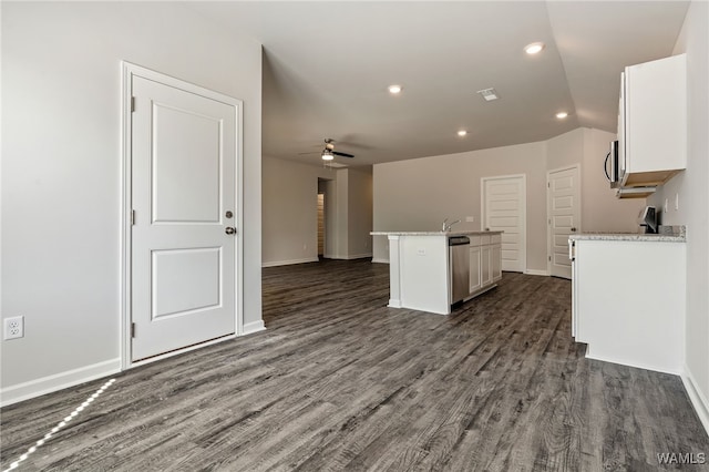 kitchen with dark hardwood / wood-style floors, white cabinetry, a kitchen island with sink, and stainless steel appliances