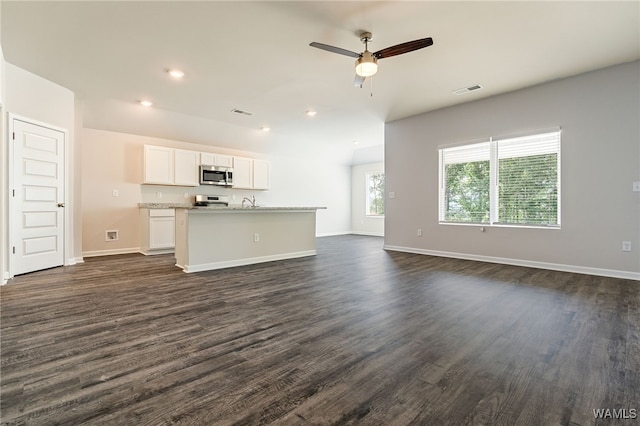 unfurnished living room with ceiling fan and dark wood-type flooring